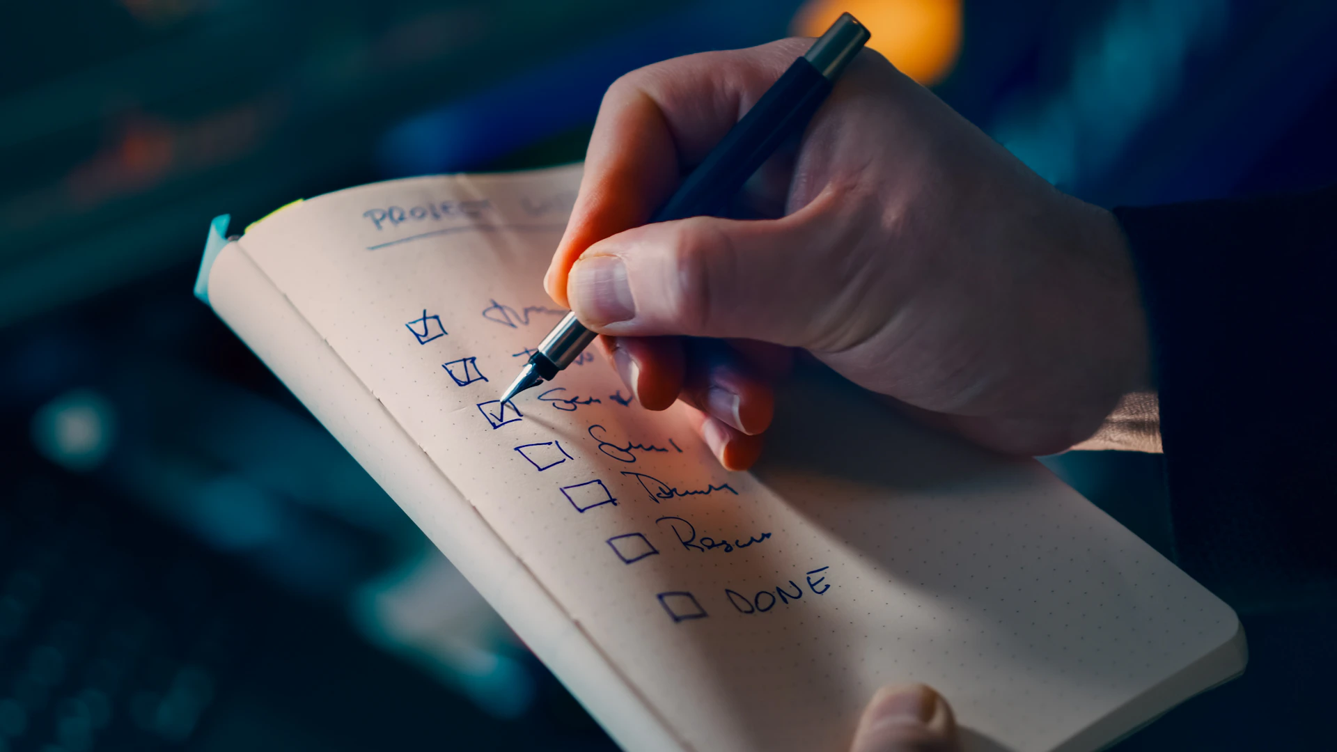 Hand writing and checking off items on a project checklist